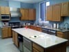 Full Kitchen Remodel � Oak Cabinets, Solid Surface Counters, Commercial Dishwashers next to Double Sinks, under counter Drawer Freezers, Commercial Range & Hood, and hand washing station.<br>Also includes (but not shown) � stacked Warming Ovens, stacked Convection Ovens, under counter Commercial Icemakers, large Commercial Refrigerator and meal planning area.